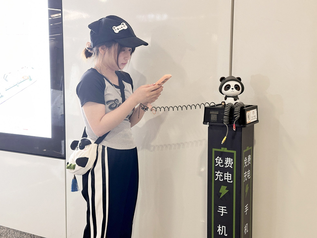 乘客正在使用免费手机充电桩充电。记者何璨汐摄
